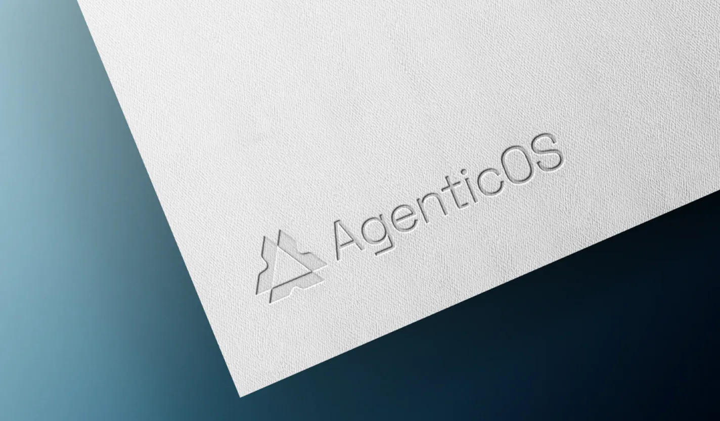 The AgenticOS lockup blind embossed into textured white paper