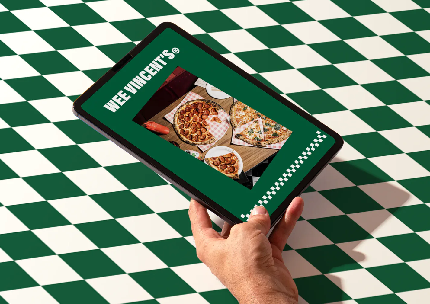 The Wee Vincent’s ordering screen held over a checkerboard table